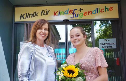 Care Managerin Carina Göbel (Kinder- und Frauenklinik) gratuliert Laura Rudolf (rechts im Bild) zum erfolgreichen Ausbildungsende. Die junge Frau aus dem Allgäu ist die letzte im Ausbildungsgang Gesundheits- und Kinderkrankenpflegerin am Klinikum Singen. Bild: Merk
